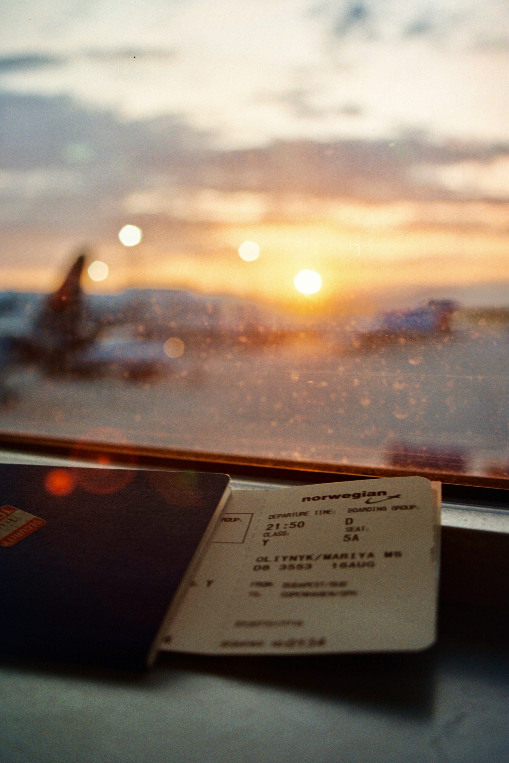 Boarding pass and passport looking out at airplanes